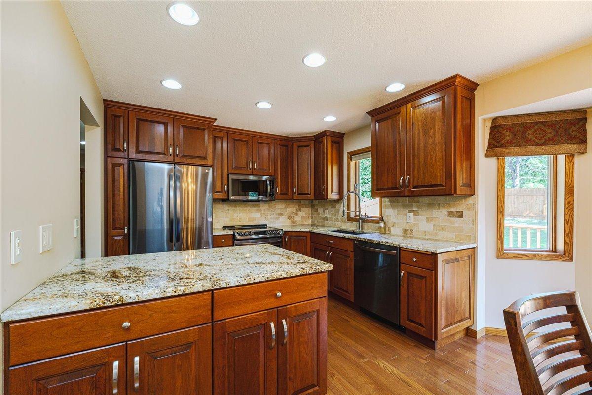 Kitchen with granite, updated appliances, and wood flooring