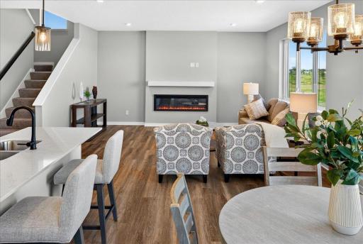 PHOTO OF A DIFFERENT HOME WITH SIMILAR PLAN & FINISHES. Dining room open to great room and kitchen.