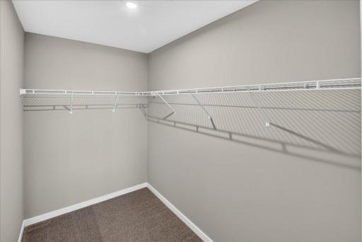 PHOTO OF A DIFFERENT HOME WITH SIMILAR PLAN & FINISHES. Primary Suite Walk-in Closet.