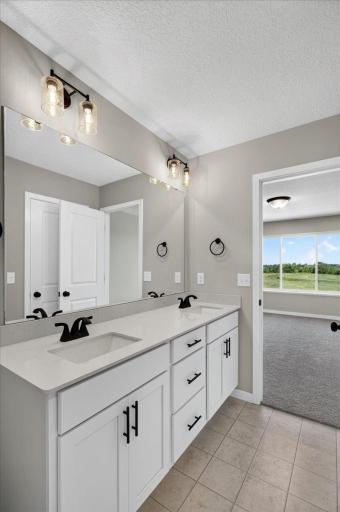 PHOTO OF A DIFFERENT HOME WITH SIMILAR PLAN & FINISHES. Primary Suite Private Bath highlights include a double sink vanity.