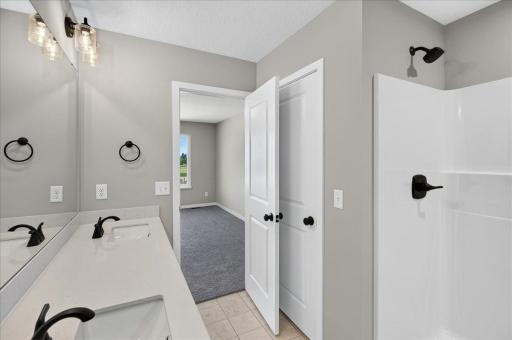 PHOTO OF A DIFFERENT HOME WITH SIMILAR PLAN & FINISHES. Primary Suite Private Bath features a linen closet offering added storage.
