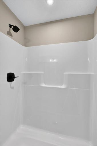 PHOTO OF A DIFFERENT HOME WITH SIMILAR PLAN & FINISHES. Primary Suite Bath features a 5' shower.