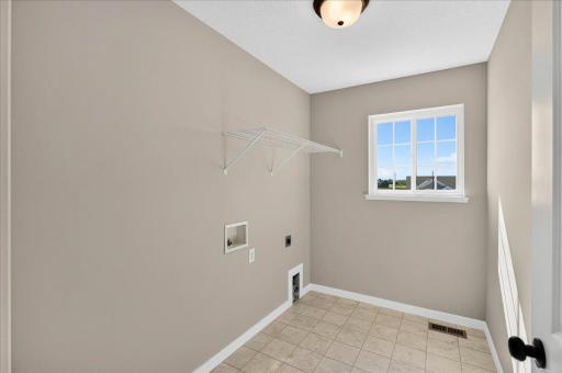 PHOTO OF A DIFFERENT HOME WITH SIMILAR PLAN & FINISHES. Upper Floor Laundry Room includes a window offering natural light.