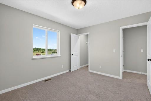 PHOTO OF A DIFFERENT HOME WITH SIMILAR PLAN & FINISHES. Bedroom 4 features a walk-in closet.