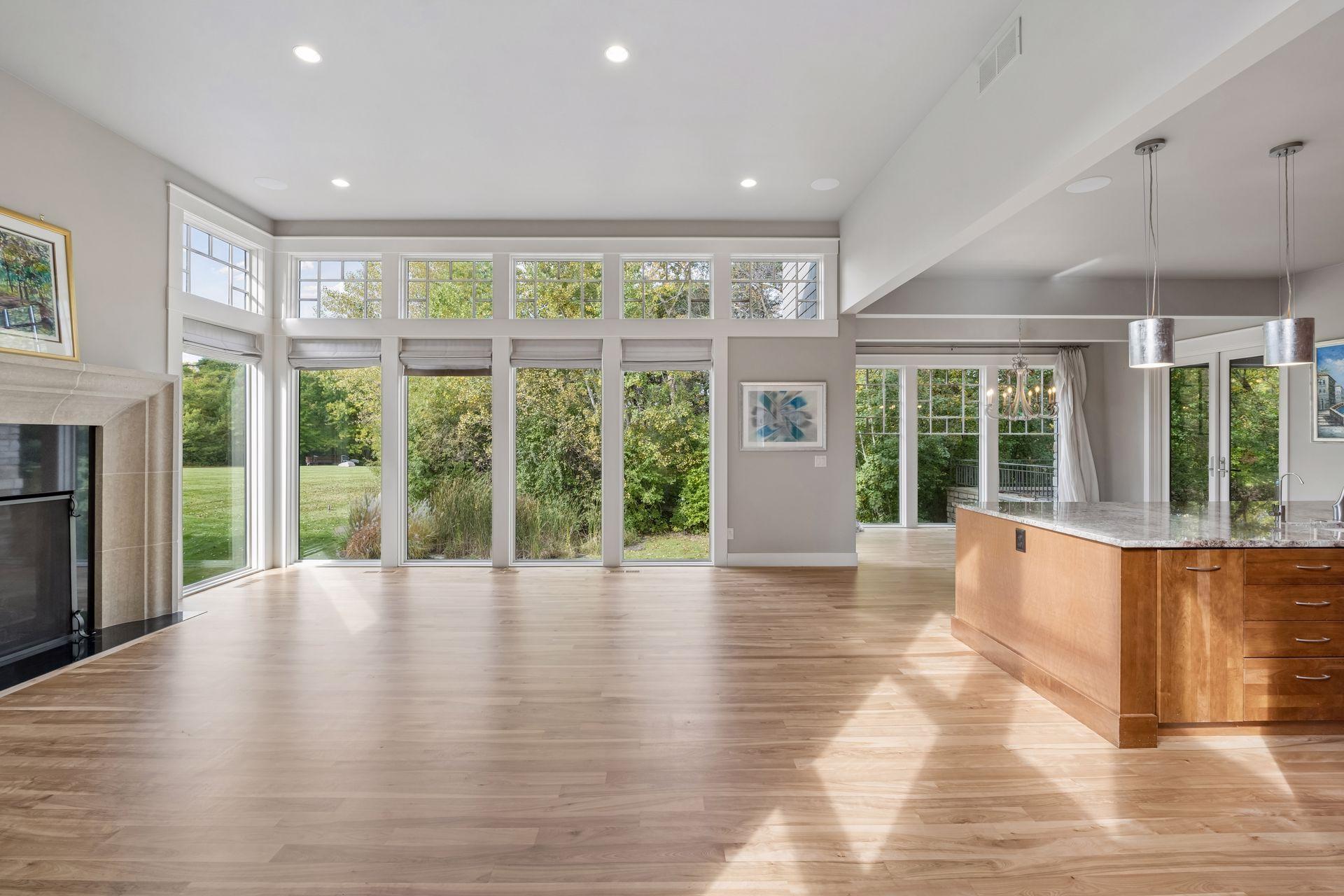 Sun-filled, open-concept living at its best! Expansive windows and soaring ceilings showcase beautiful hardwood floors while filling the space with natural light. Enjoy seamless indoor-outdoor views and a bright, inviting layout perfect for everyday