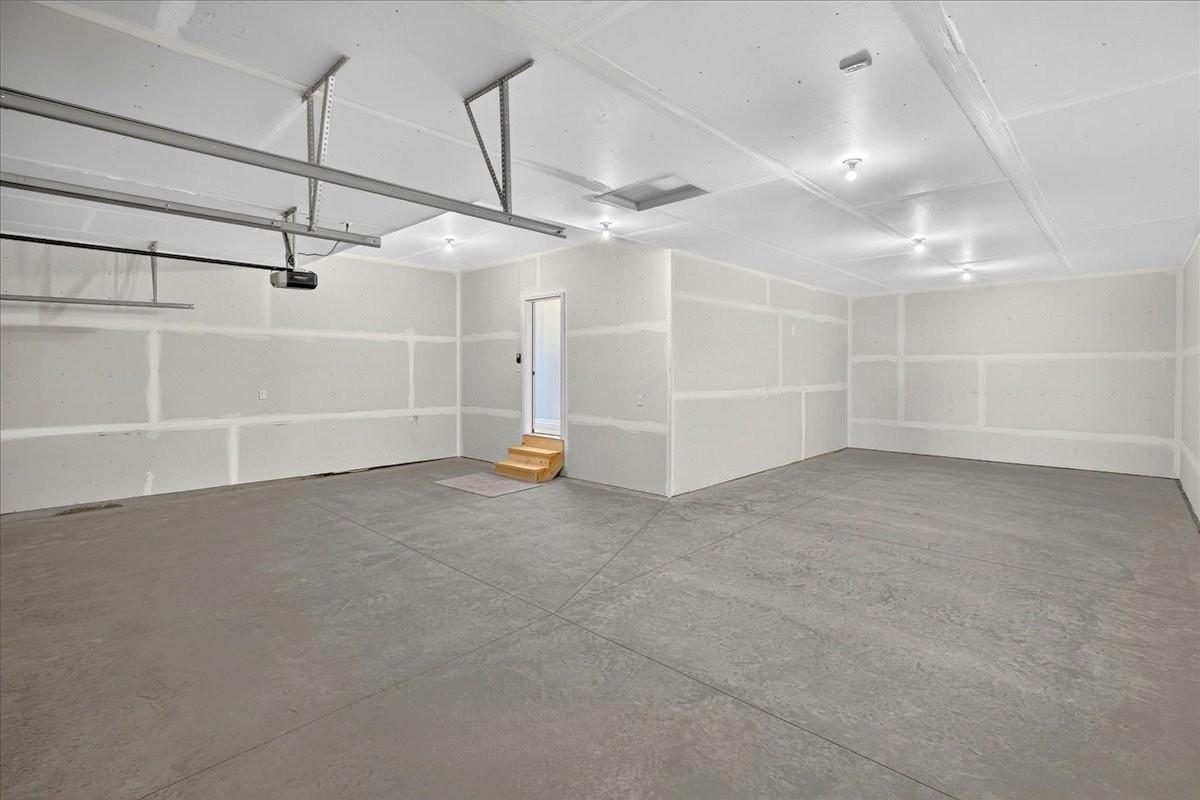 PHOTO OF A DIFFERENT HOME WITH SIMILAR PLAN & FINISHES. Spacious 4 BAY GARAGE (934 sq.ft.) offering an abundance of work space and storage! 3 stalls across the front of home and 4th bay tandem.