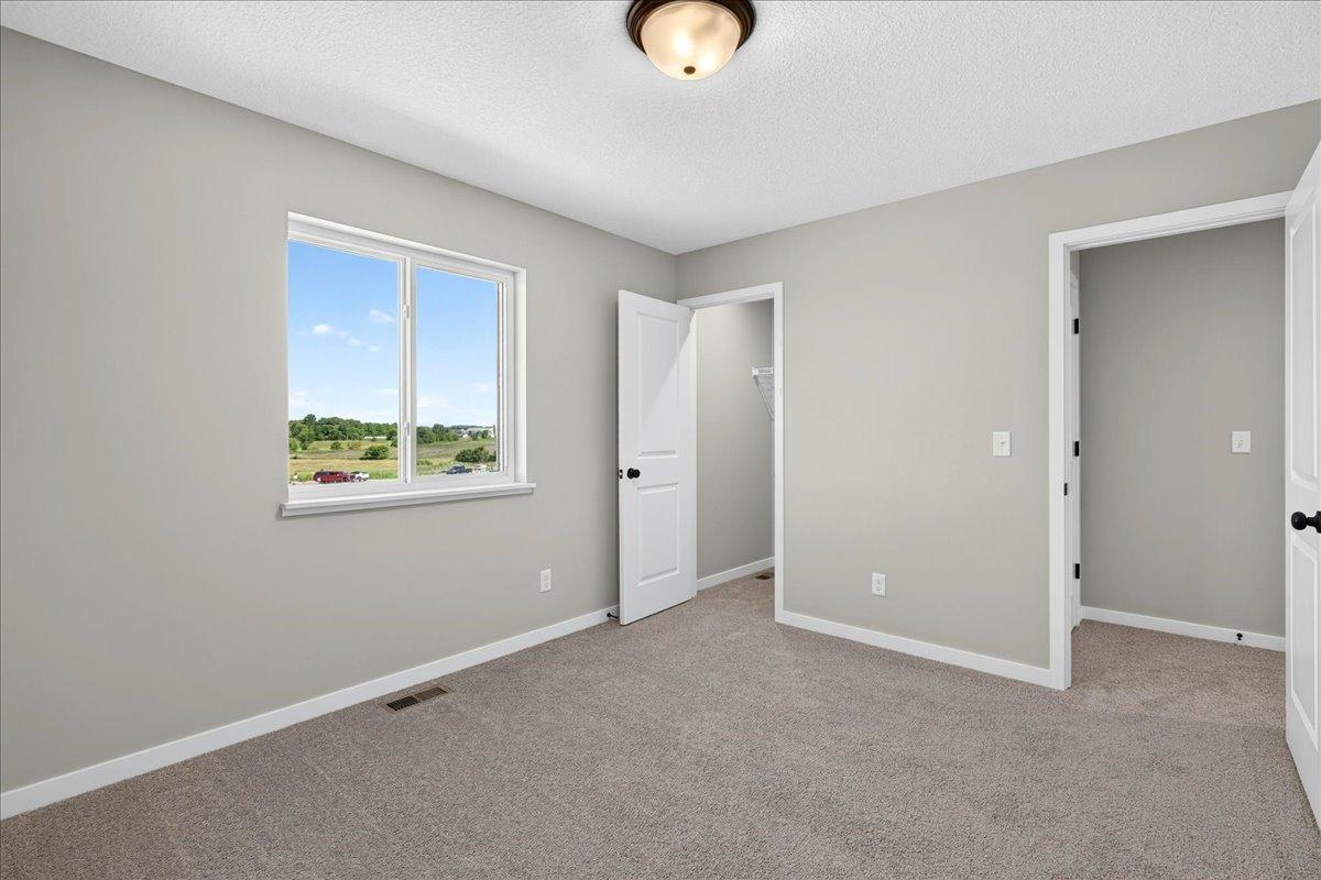 PHOTO OF A DIFFERENT HOME WITH SIMILAR PLAN & FINISHES. Bedroom 4 features a walk-in closet.