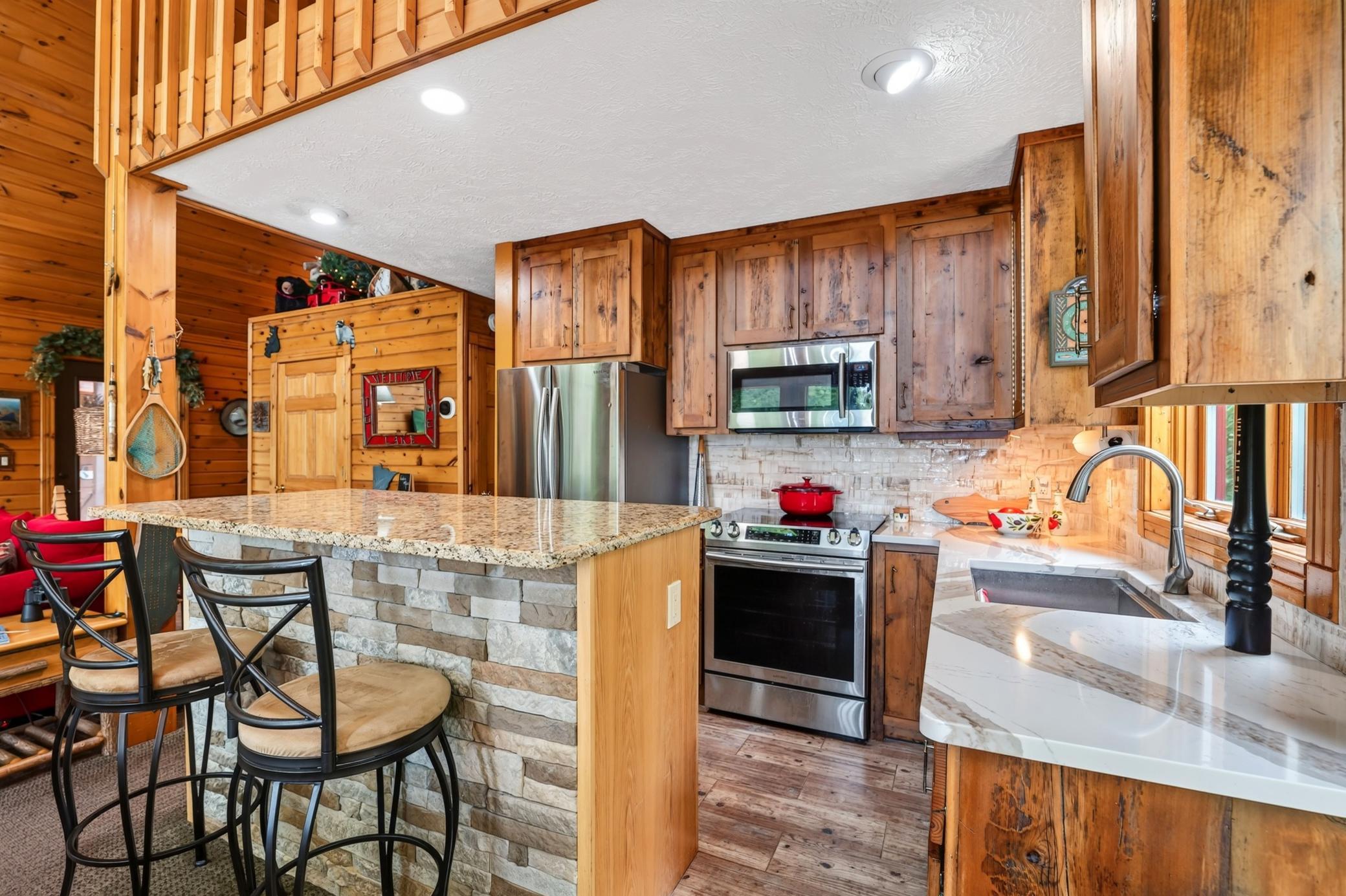 Updated kitchen with a stone countertop island and seating.