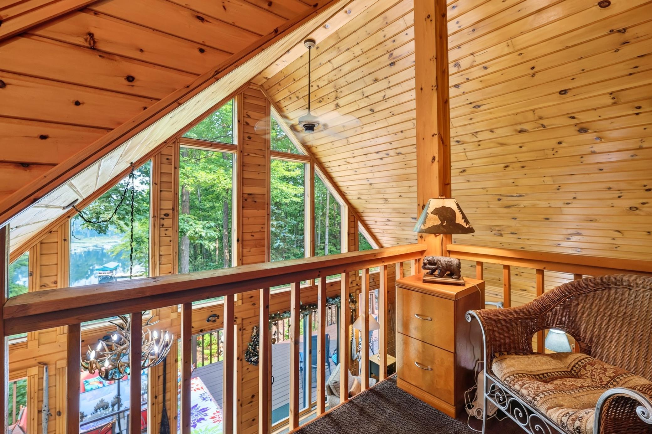 Knotty pine vaulted ceiling with fan.