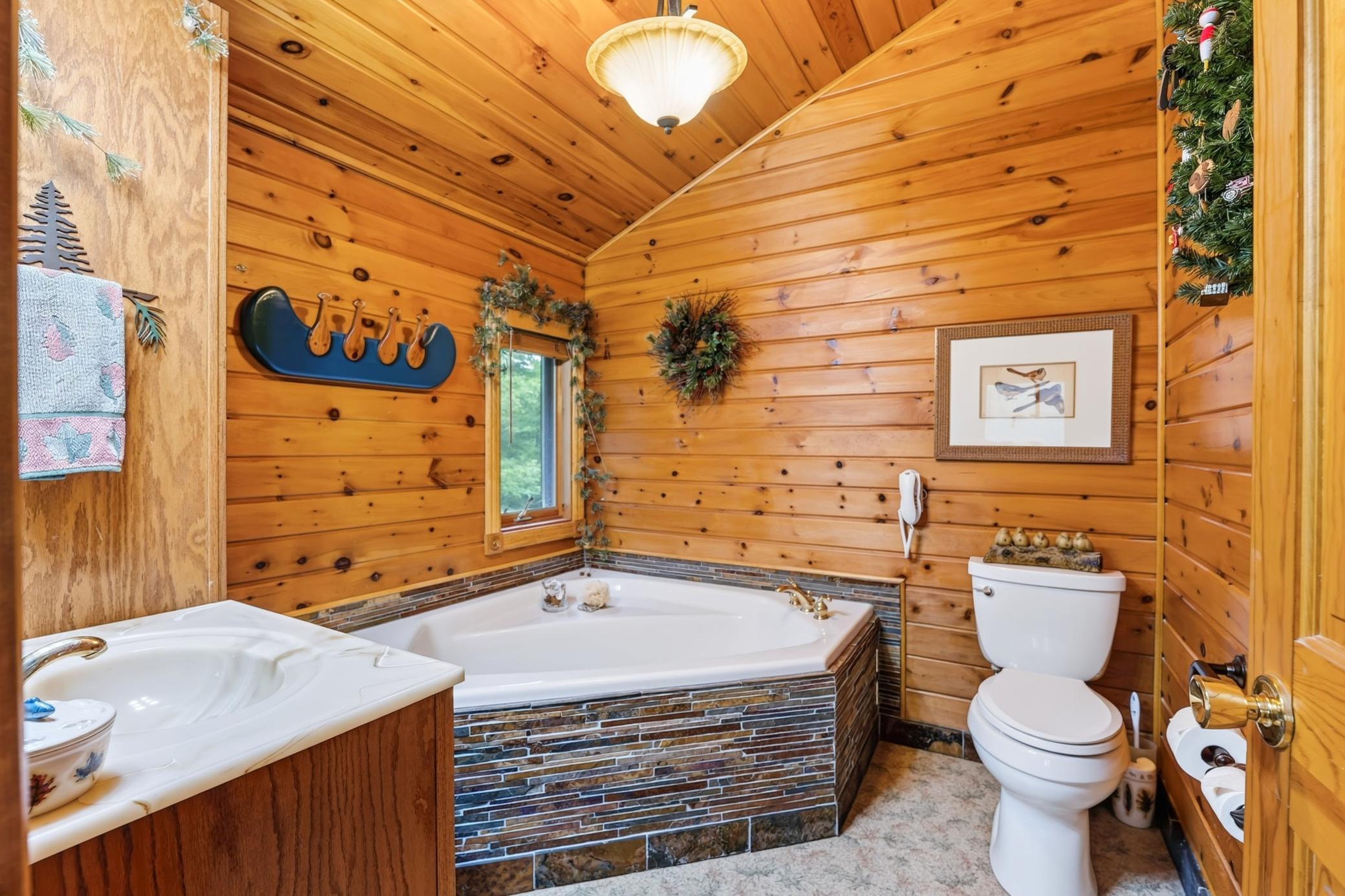 Warm knotty pine spa like bathroom with soaking tub.