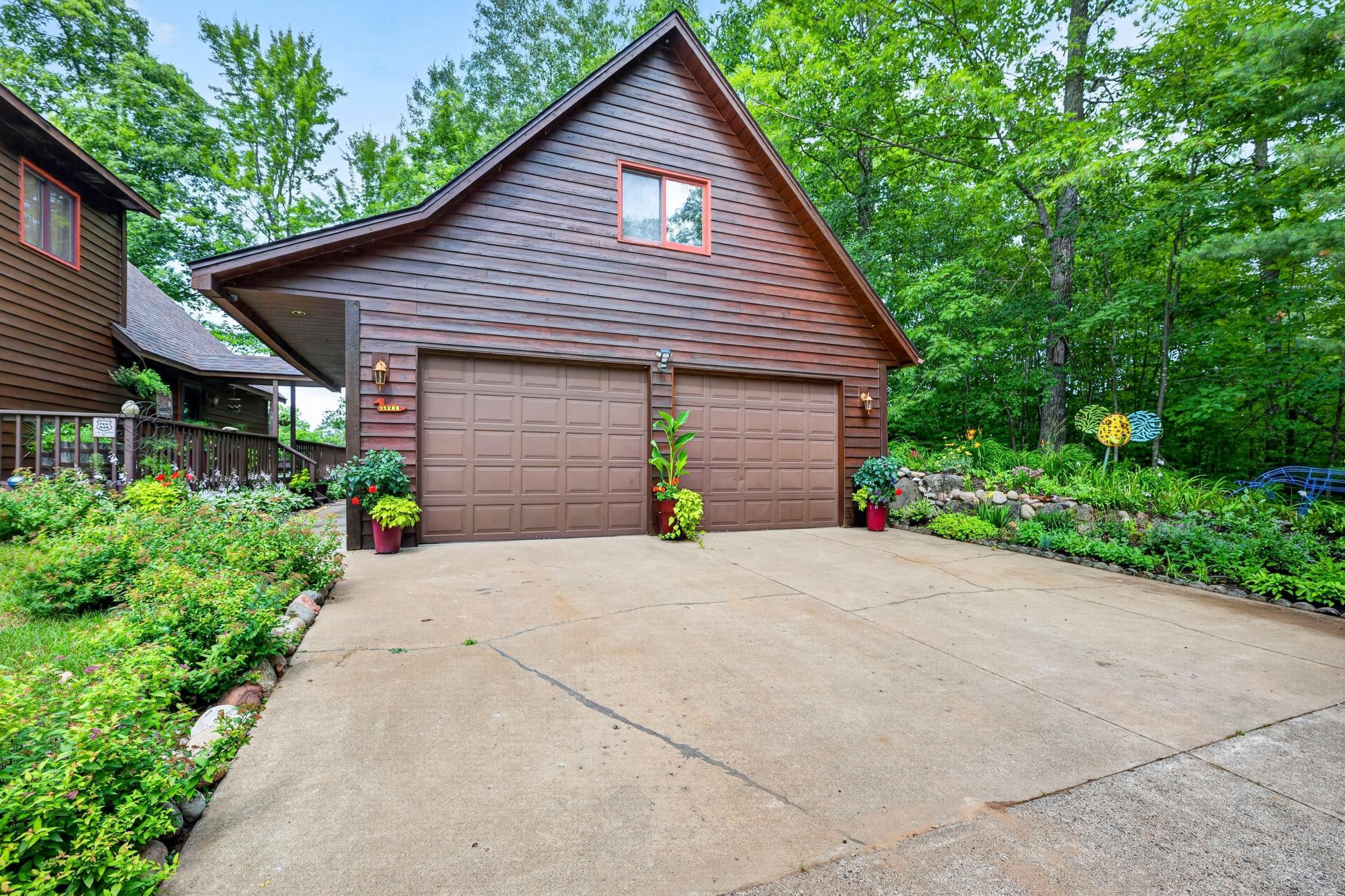 Large two-car garage with upper loft and cement driveway.