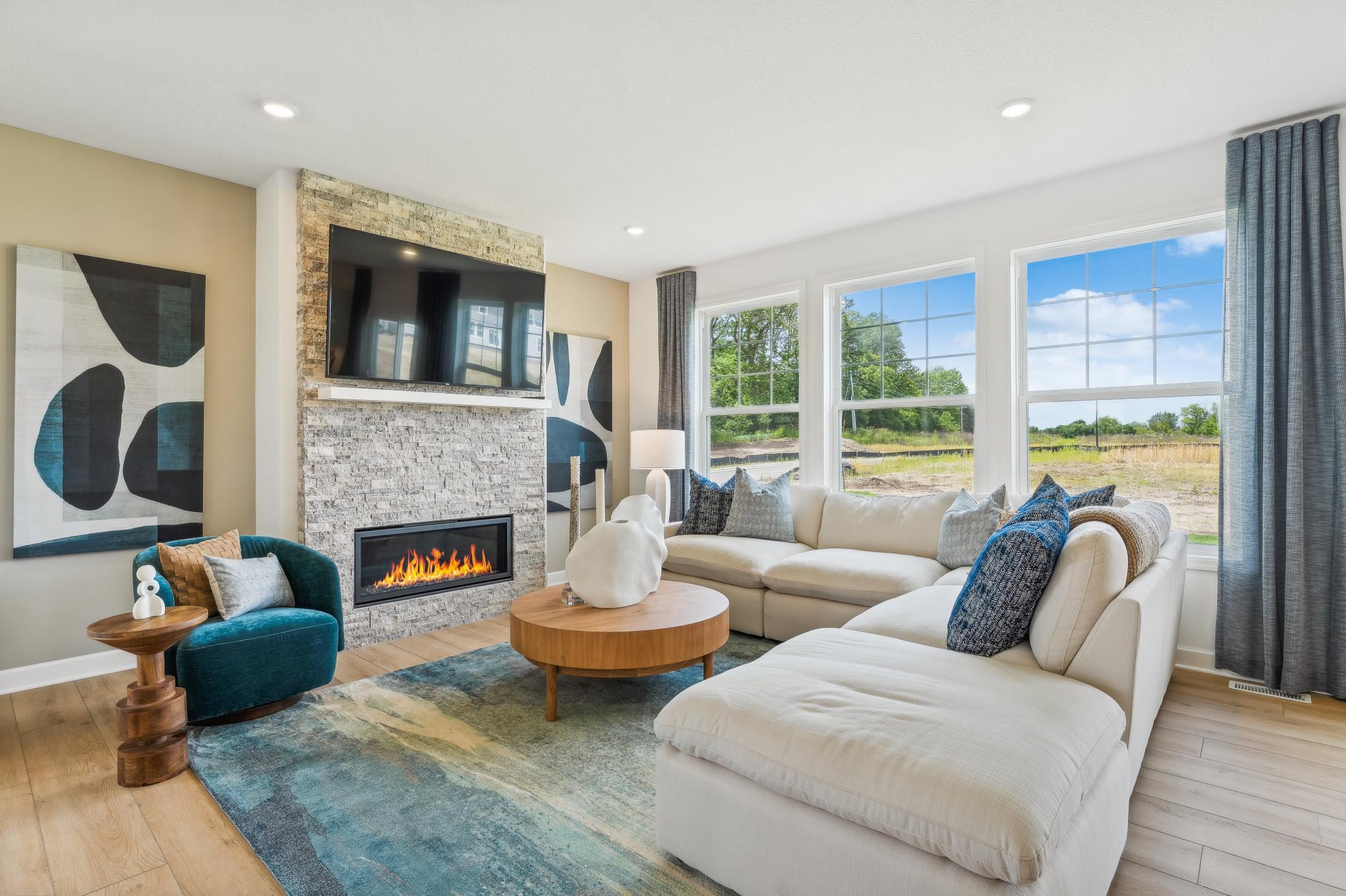 (Photo of model home, finishes will vary) A wall of large windows in the Great Room offer a sunlit view of the neighborhood and brighten daytime gatherings. It’s an ideal space for relaxing and enjoying the company of loved ones.