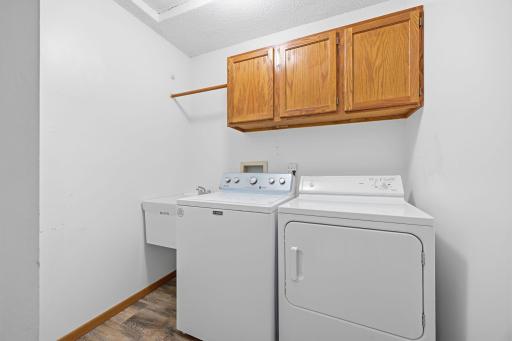 Main floor laundry room with utility sink and newer flooring.