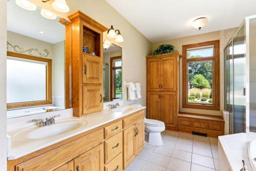Spa-like primary bathroom with heated tile floor, dual vanity