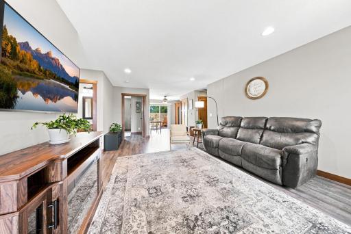 Filled with natural light, the spacious living room flows seamlessly into the dining area and kitchen featuring rich wood cabinetry, stainless steel appliances, and easy access to the backyard patio for effortless indoor and outdoor living.