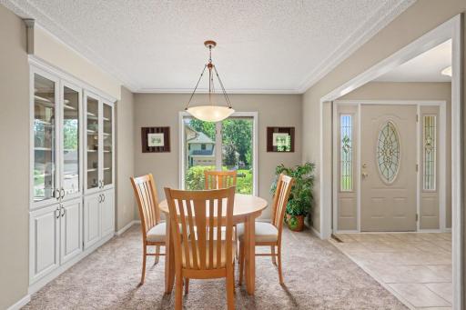Just off the foyer is the formal dining room. It offers: updated carpet (2019), painted walls & trim (2024), a built-in china cabinet, racetrack ceiling w/an updated chandelier (w/dimmer switch), and a south-facing window for lots of natural light.