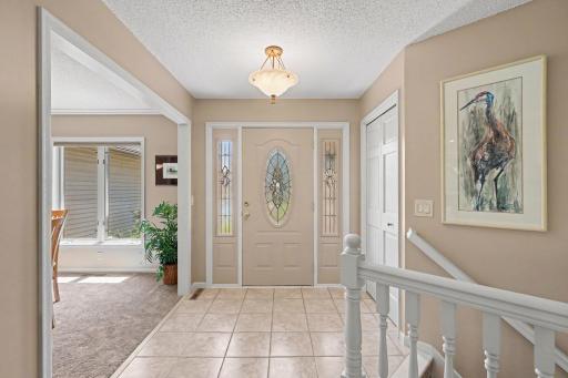 The foyer features: painted walls & trim (2024), a custom Anderson front door flanked by 2 sidelights, a convenient coat closet, and ceramic tile flooring. This home has 6 panel interior door throughout.