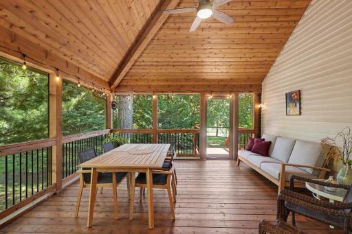 This beautiful, private screened porch was added in 2016, and faces east & north. It features: a vaulted, knotty pine ceiling with ceiling fan; and knotty pine flooring.