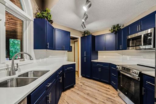 A closer view of the kitchen which leads to the back hallway - offering convenient access to the attached garage and the main floor laundry room.