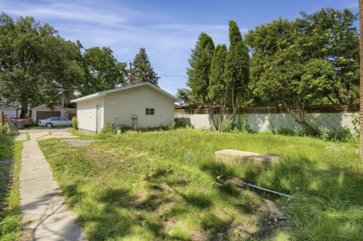 Backyard showing two car garage and 2 car concrete slab