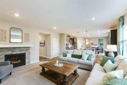 Living room with a dual sided fireplace. *Photo of previously built model home. Finishes and selections to vary.