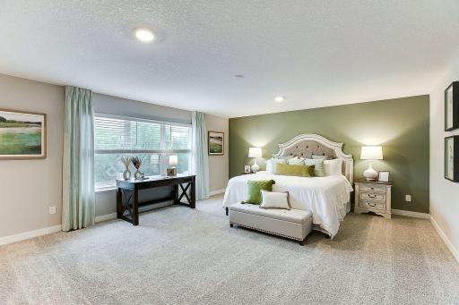 Primary suite is off the front of the home with large windows to let in the light. *Photo of previously built model home. Finishes and selections to vary.