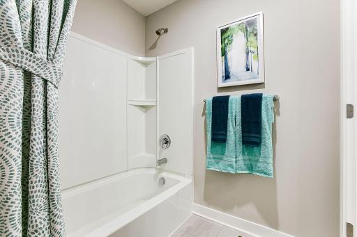 Full tub and shower combination, behind a door for added privacy from the sinks. *Photo of previously built model home. Finishes and selections to vary.