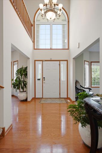 The large & impressive two-story foyer features huge windows, abundant natural light, hardwood flooring and modern, neutral paint.