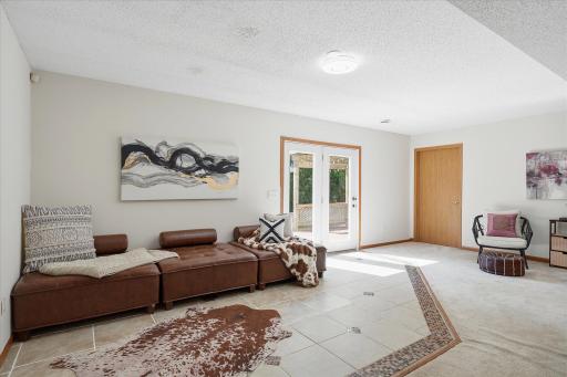 The family/rec room features tile flooring with mosaic accents, neutral tones and walk out directlt to a stamped concrete patio!