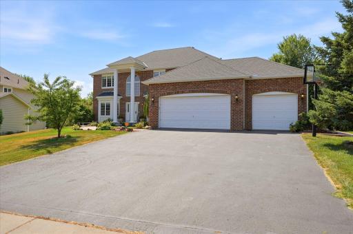 The recently seal-coated asphalt leads to an enormous, oversized three car garage!