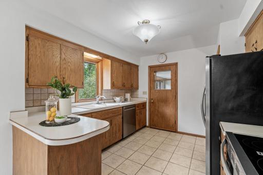 Kitchen w/ abundant cabinetry, tile backsplash & SS apps
