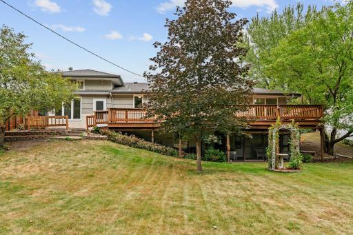 Private backyard w/ mature trees, green space + two storage sheds