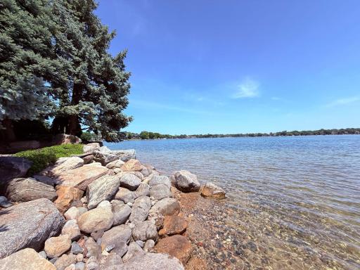 Sandy shoreline with large rip rap boulders