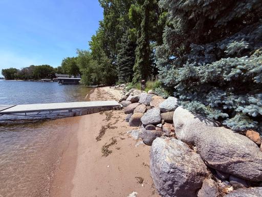 Sandy shoreline with large rip rap boulders