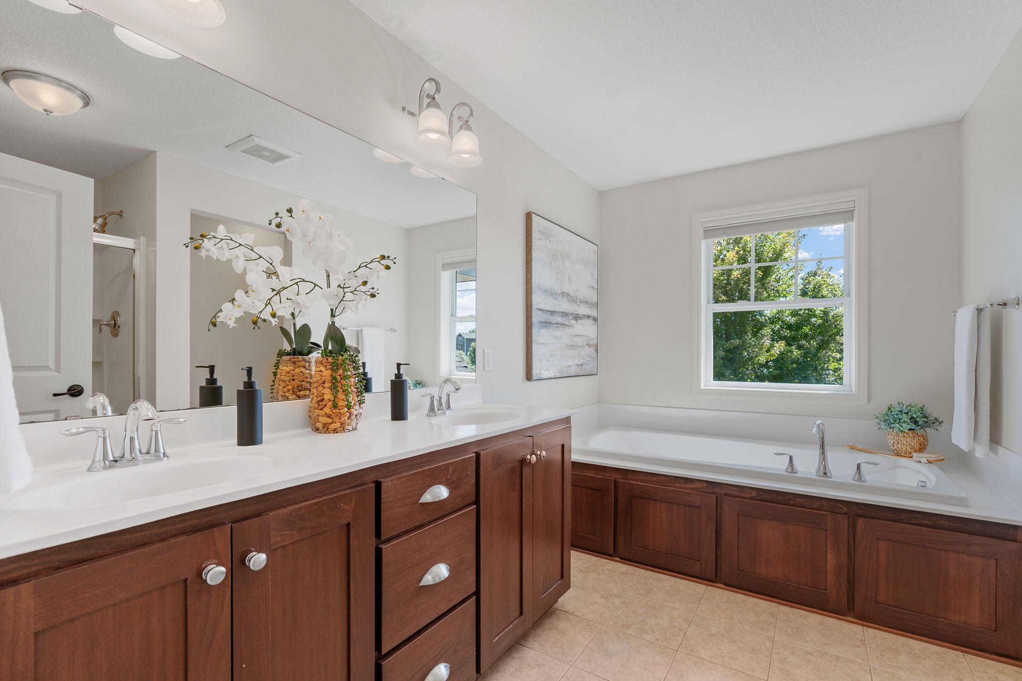 Spacious Primary Suite w/ vaulted ceiling, oversized walk-in closet, dual sinks + separate tub/shower