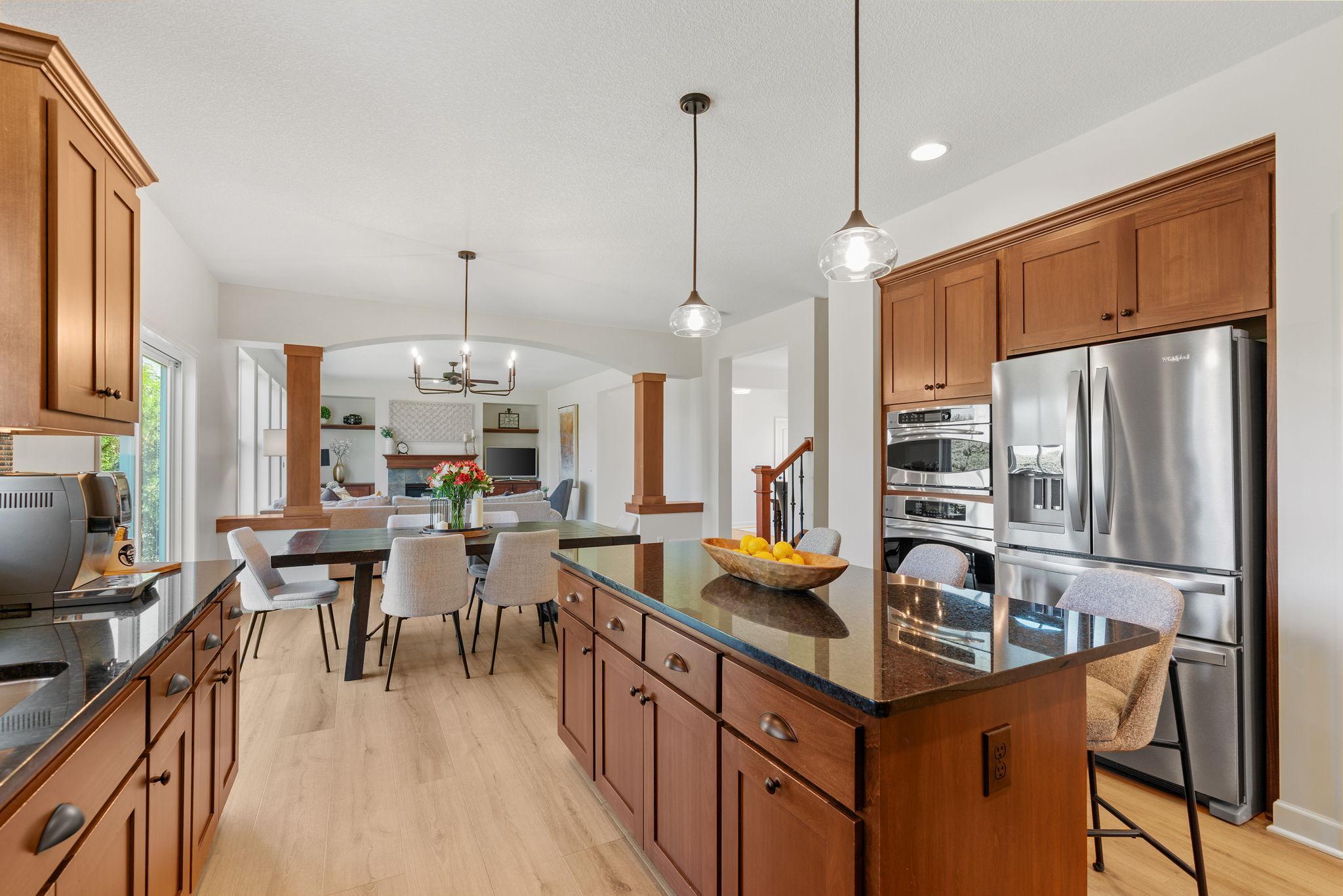 Gourmet Kitchen w/ large center island, granite counters, tons of cabinetry, SS apps, hood + walk-in pantry