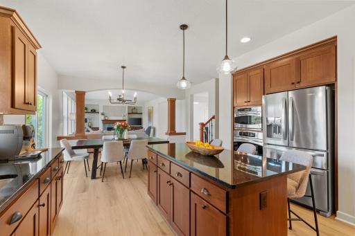 Gourmet Kitchen w/ large center island, granite counters, tons of cabinetry, SS apps, hood + walk-in pantry