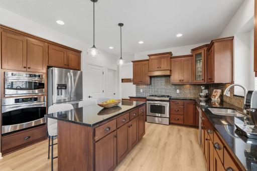 Gourmet Kitchen w/ large center island, granite counters, tons of cabinetry, SS apps, hood + walk-in pantry