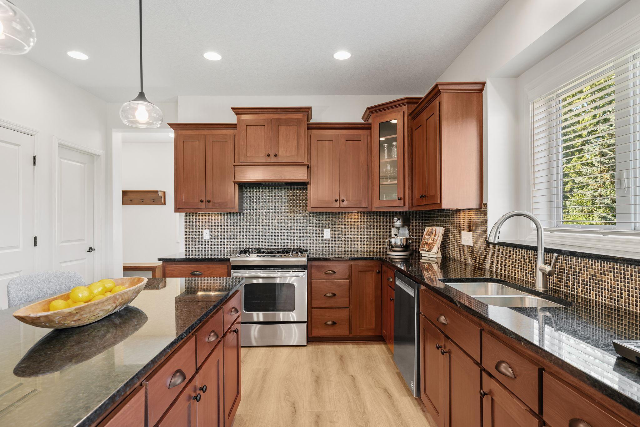 Gourmet Kitchen w/ large center island, granite counters, tons of cabinetry, SS apps, hood + walk-in pantry