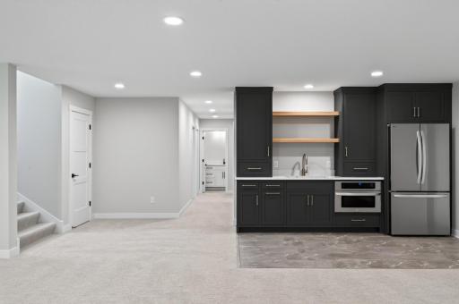 Lower level wet bar area with a full-size fridge and microwave!