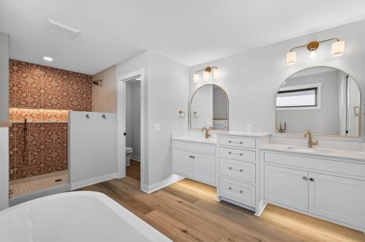 Primary bathroom ensuite with: double sinks, floating tub, convenience lighting, fully tiled shower, separate toilet room, and built-in dresser! **shower will have a frameless glass door.