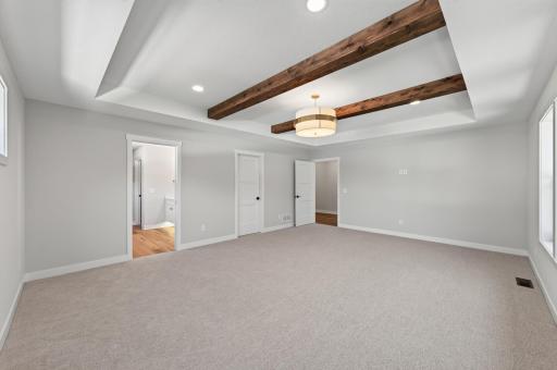 Primary bedroom is oversized with wood beams, a full primary ensuite and a massive walk-in closet!