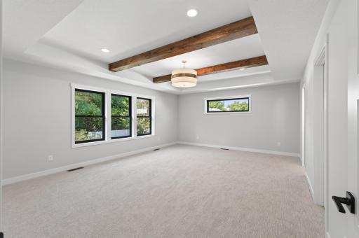 Primary bedroom is oversized with wood beams, a full primary ensuite and a massive walk-in closet!