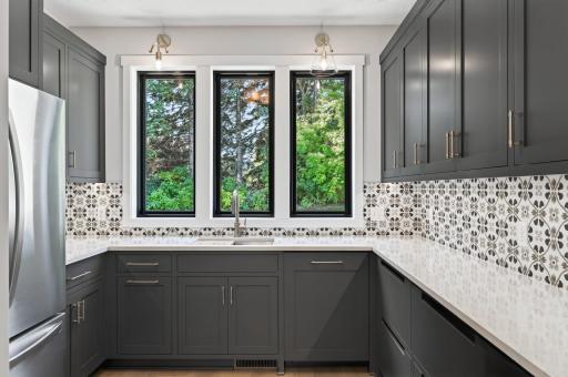 This butler's pantry is stocked with a dishwasher, sink and a full size fridge! A chef's dream!