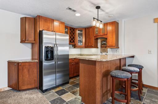 Wet bar with full fridge and custom cabinetry.
