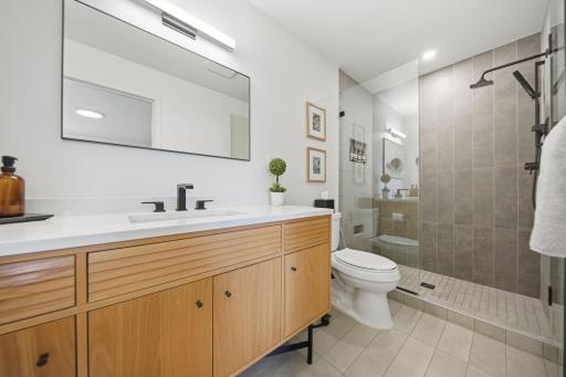 The primary bathroom is a total remodel! New walk-in shower (tile and glass shower door). New tile floor and tile base. New vanity and mirror. New base, trim, lighting and paint.