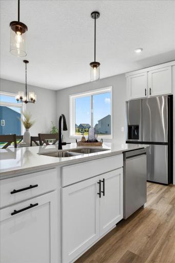 PHOTO OF A DIFFERENT HOME WITH SIMILAR PLAN AND FINISHES. Kitchen Center Island features a Trash/Recycled Base Cabinet Pullout convenient to the sink.