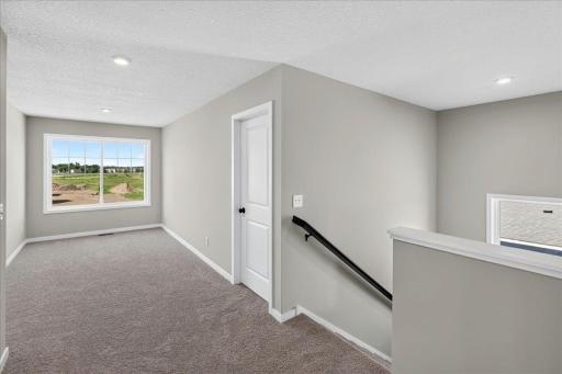 PHOTO OF A DIFFERENT HOME WITH SIMILAR PLAN AND FINISHES. Upper Hallway view to the loft and staircase.