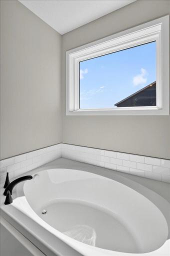 PHOTO OF A DIFFERENT HOME WITH SIMILAR PLAN AND FINISHES. Primary Deluxe Bath Soaking Tub.