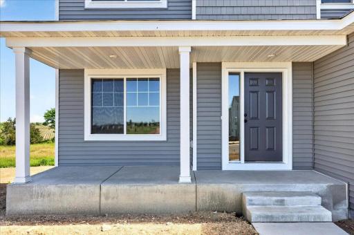 PHOTO OF A DIFFERENT HOME WITH SIMILAR PLAN AND FINISHES. Spacious Concrete Front Porch.